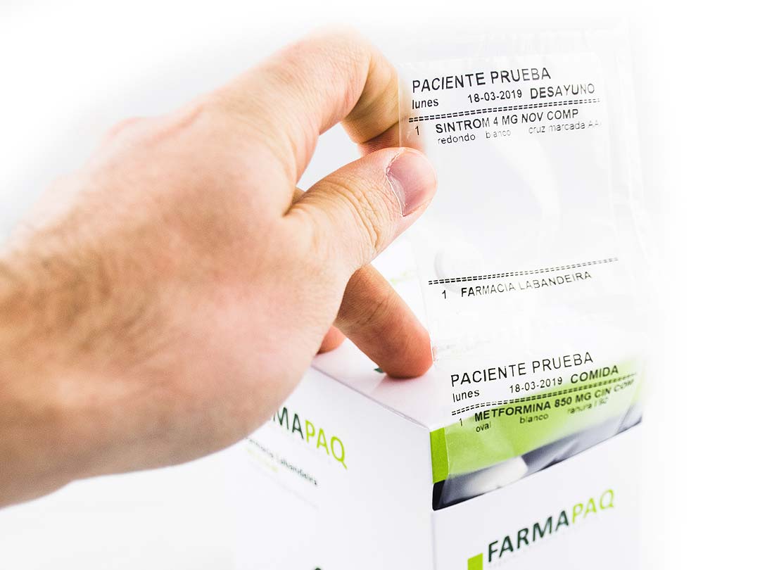 Mano de una persona sacando una bolsa hermética de un Farmapaq, el pastillero semanal elaborado por Farmacia Labandeira.